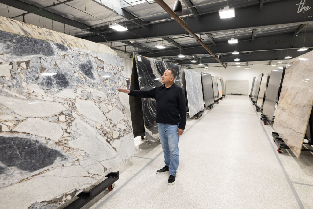 Trade professional reviewing natural stone slabs at The Slab Studio while selecting materials for an outdoor kitchen project in Southern California.