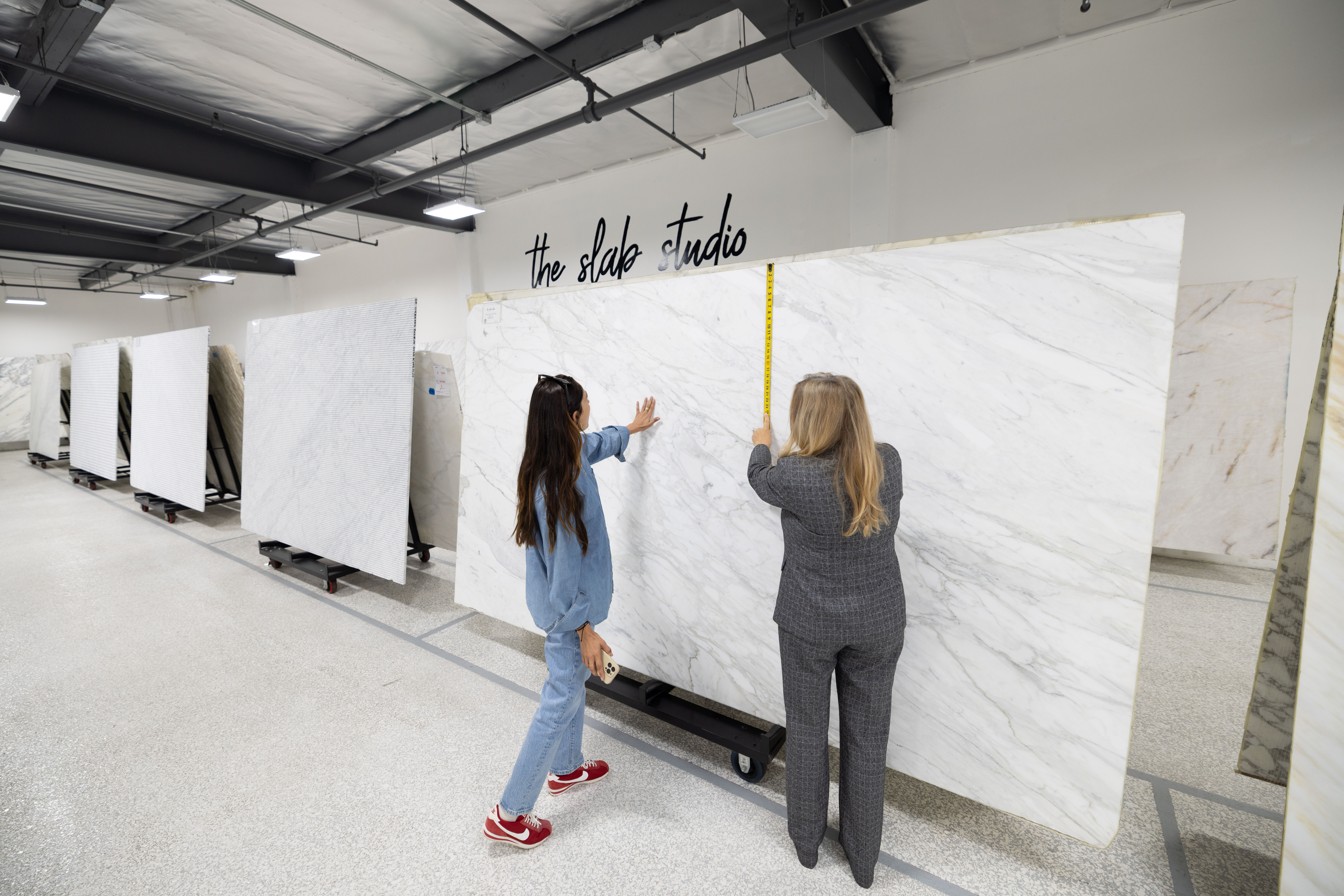 Trade professionals reviewing natural stone slabs for an outdoor kitchen project at The Slab Studio in Santa Ana.