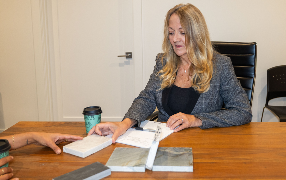 Jill Kummer reviewing natural stone samples at The Slab Studio in Santa Ana with more than 27 years of industry experience.