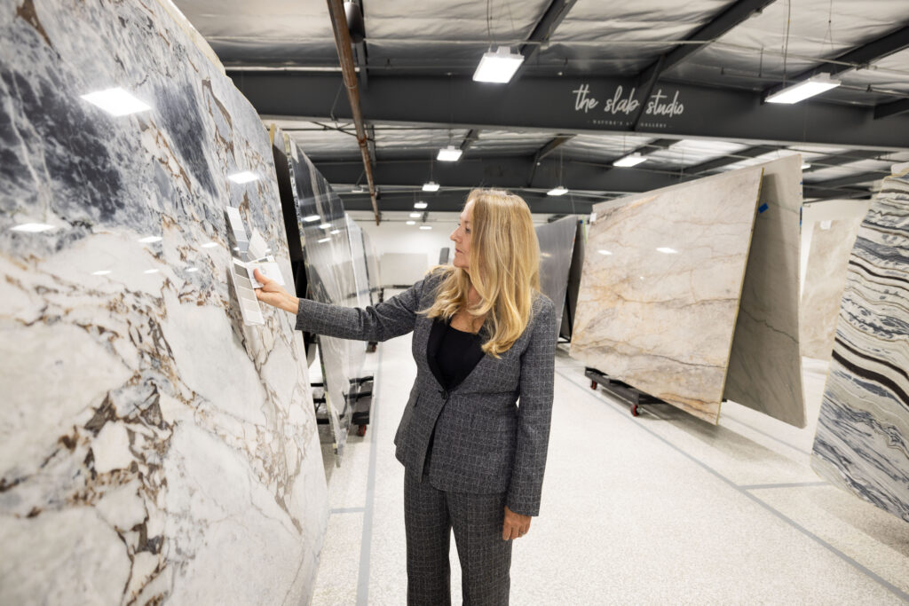Trade professional evaluating veined stone slab at The Slab Studio Santa Ana