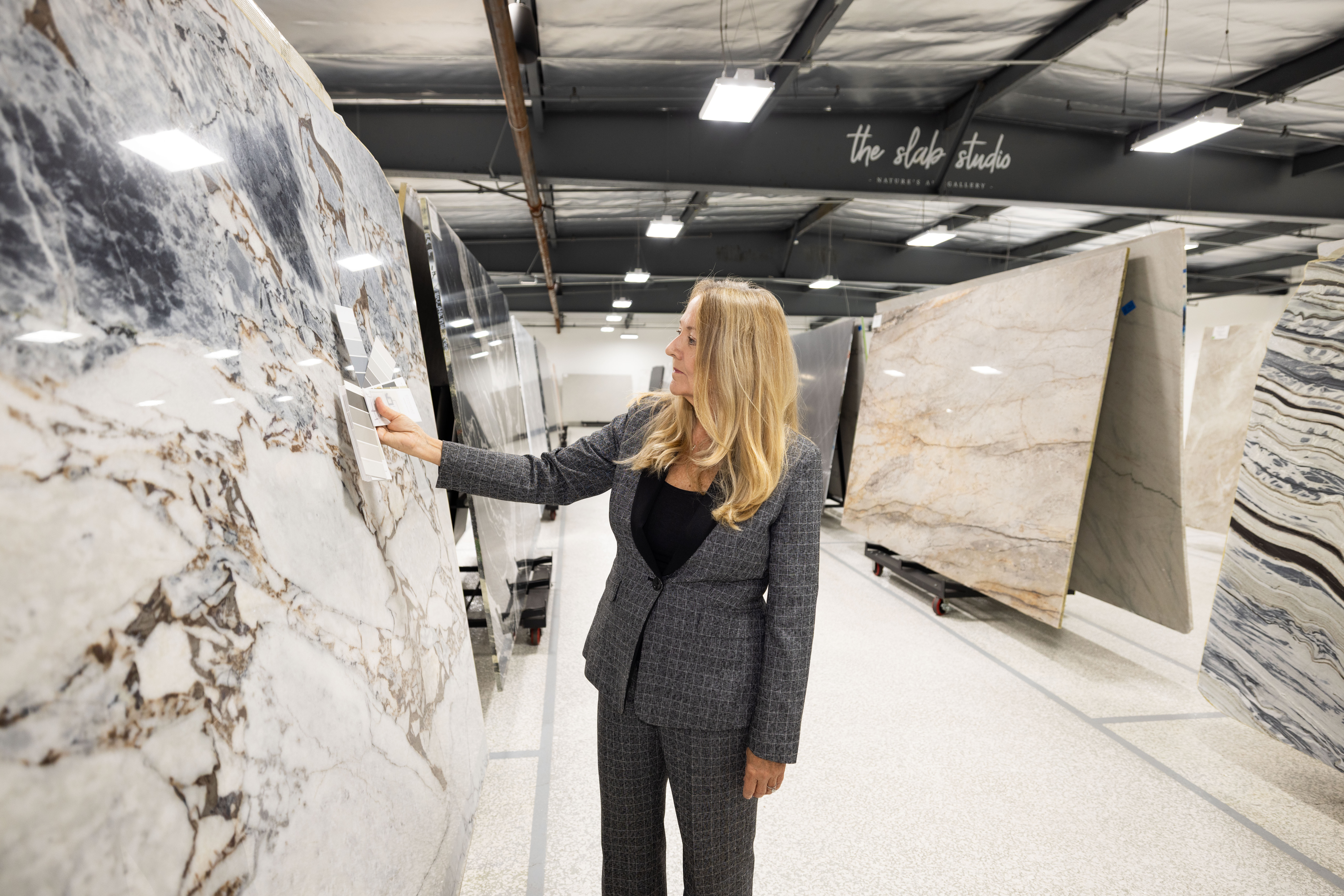 Trade professional evaluating veined stone slab at The Slab Studio Santa Ana